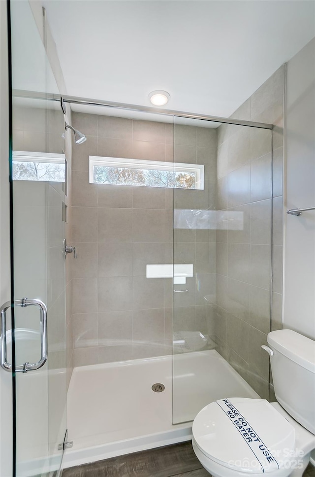 full bathroom featuring toilet and tiled shower