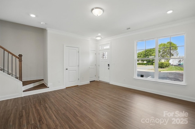 entrance foyer featuring dark wood finished floors, stairway, a healthy amount of sunlight, and ornamental molding