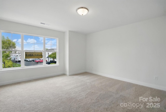 carpeted spare room with baseboards and visible vents