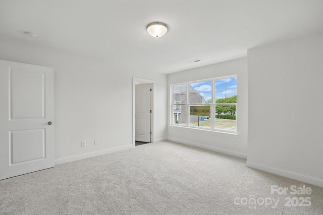empty room with visible vents, baseboards, and carpet floors