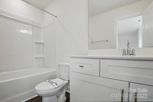 bathroom featuring toilet, vanity, wood finished floors, and tub / shower combination