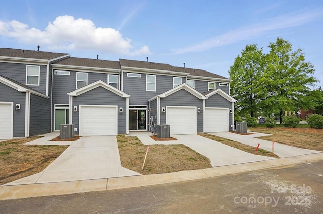 townhome / multi-family property featuring central air condition unit and concrete driveway