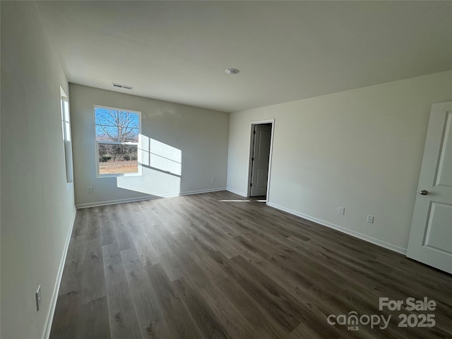 empty room with dark hardwood / wood-style flooring