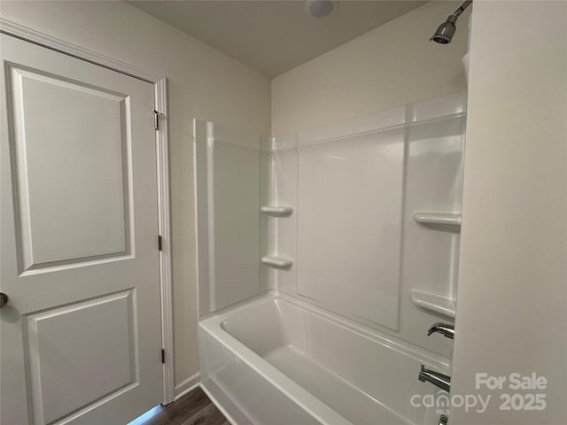 bathroom with hardwood / wood-style floors and bathtub / shower combination