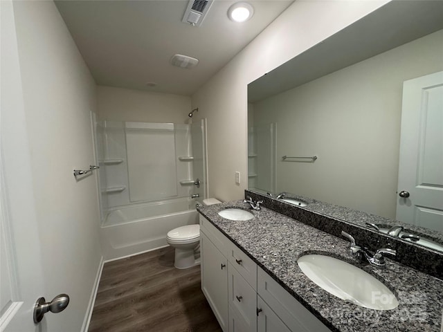 full bathroom featuring hardwood / wood-style flooring, vanity, shower / bathtub combination, and toilet