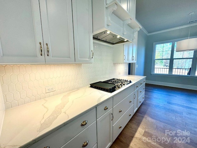 kitchen with white cabinets, dark hardwood / wood-style floors, gas stovetop, ornamental molding, and light stone counters