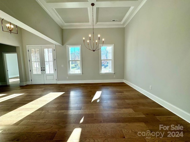 unfurnished dining area featuring french doors, coffered ceiling, dark wood-type flooring, and a notable chandelier