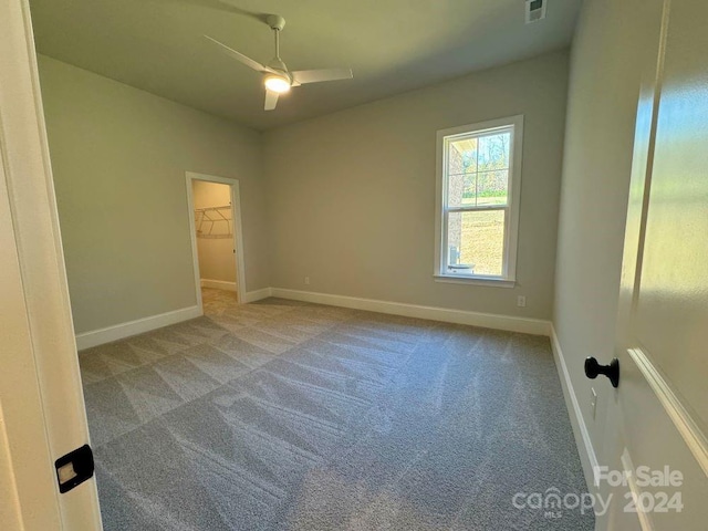 empty room with ceiling fan and carpet