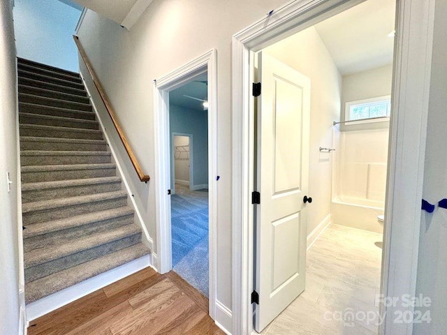 stairs featuring hardwood / wood-style flooring and vaulted ceiling