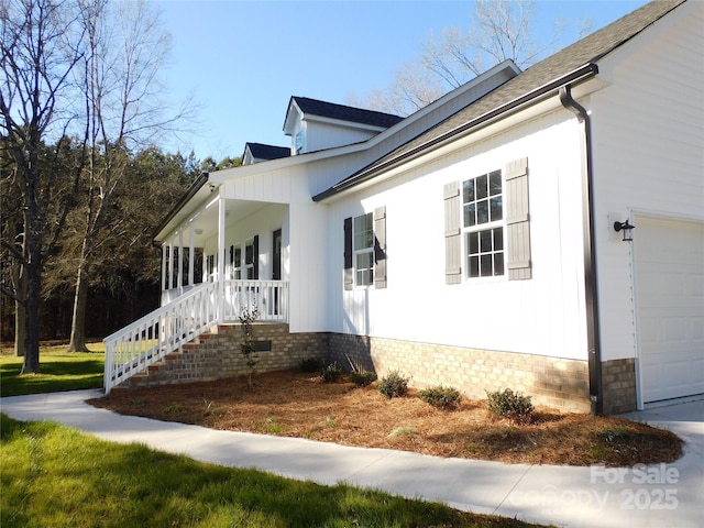 view of property exterior with a garage and covered porch