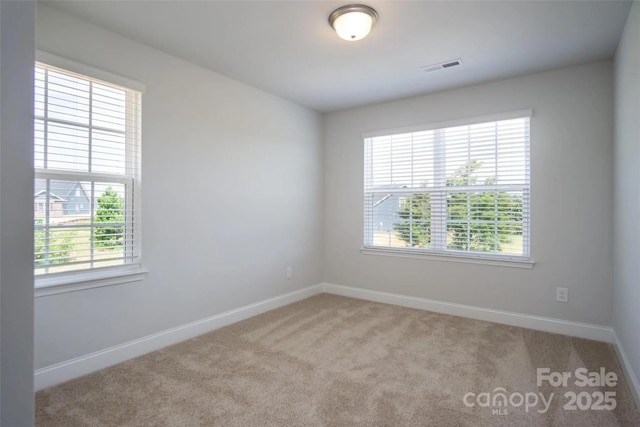 unfurnished room featuring light carpet