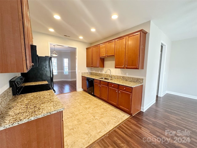 kitchen featuring sink, light wood-type flooring, light stone countertops, and black appliances