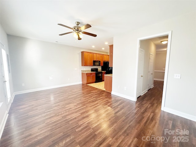 unfurnished living room featuring dark wood-type flooring and ceiling fan