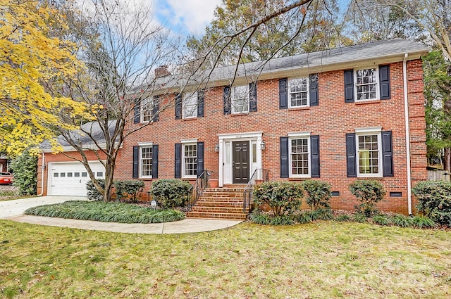 colonial-style house featuring a garage and a front lawn