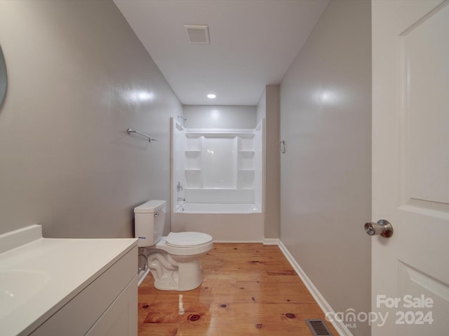 full bathroom with washtub / shower combination, vanity, hardwood / wood-style flooring, and toilet