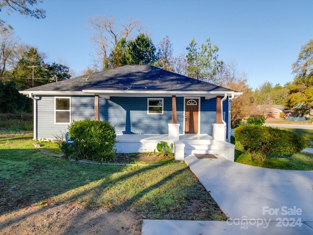 ranch-style home with a porch and a front yard