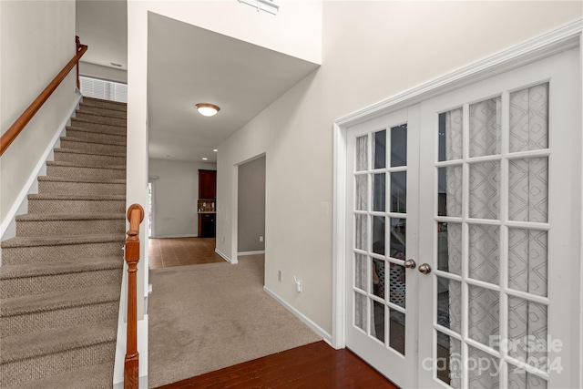 staircase with french doors and hardwood / wood-style flooring