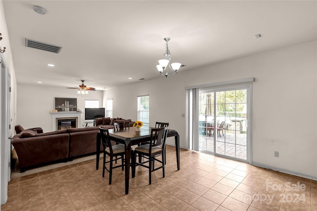 dining room featuring light tile patterned floors and ceiling fan with notable chandelier