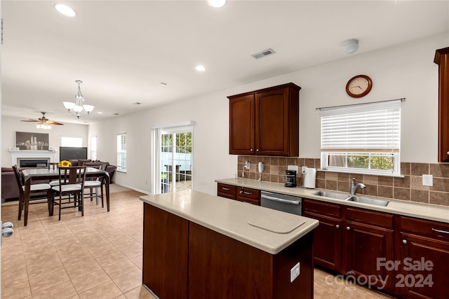 kitchen with dishwasher, sink, a center island, and a healthy amount of sunlight