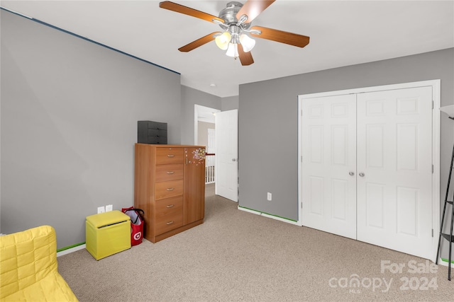 carpeted bedroom featuring a closet and ceiling fan