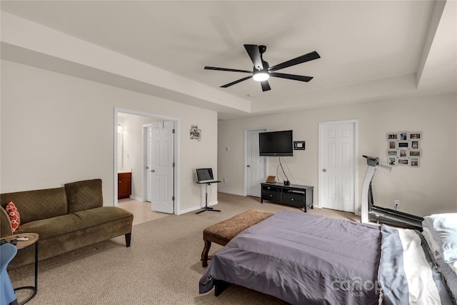 bedroom with a raised ceiling, ceiling fan, carpet, and ensuite bathroom