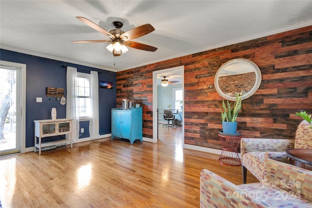 living area featuring light hardwood / wood-style floors, a wealth of natural light, and ornamental molding