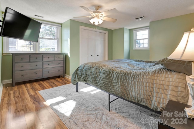 bedroom with ceiling fan, a closet, a textured ceiling, and light hardwood / wood-style flooring