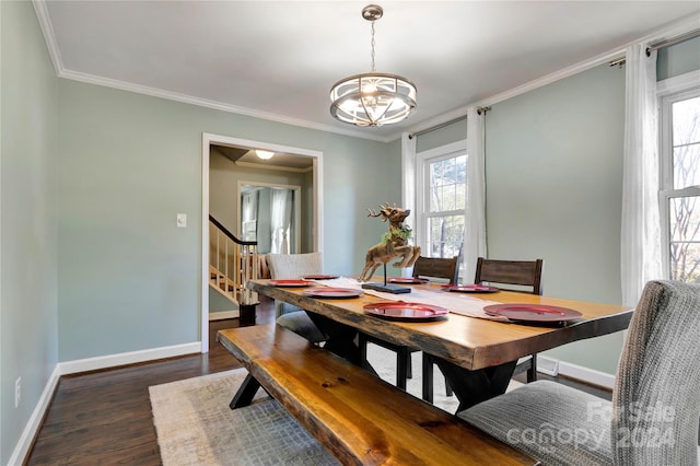 dining area featuring crown molding, dark wood-type flooring, and an inviting chandelier