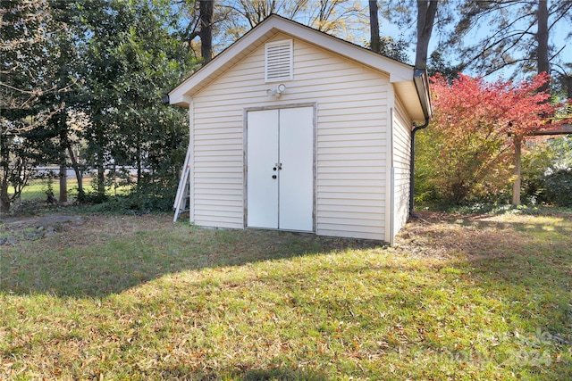 view of outbuilding featuring a lawn