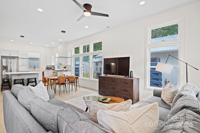 living room with ceiling fan, plenty of natural light, and sink