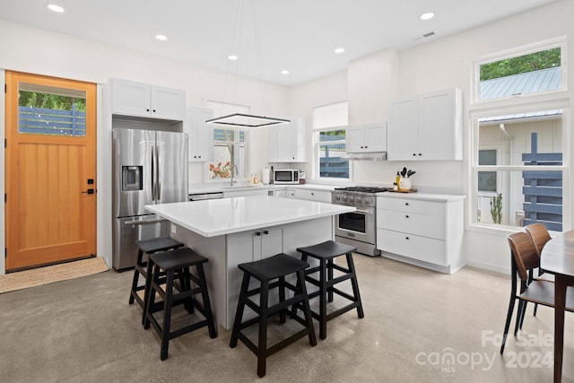 kitchen featuring sink, a breakfast bar area, a kitchen island, white cabinetry, and stainless steel appliances