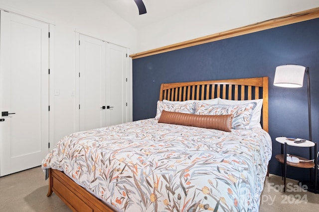 bedroom featuring ceiling fan, lofted ceiling, and light carpet