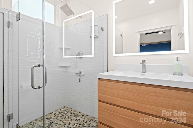 bathroom featuring vanity and an enclosed shower