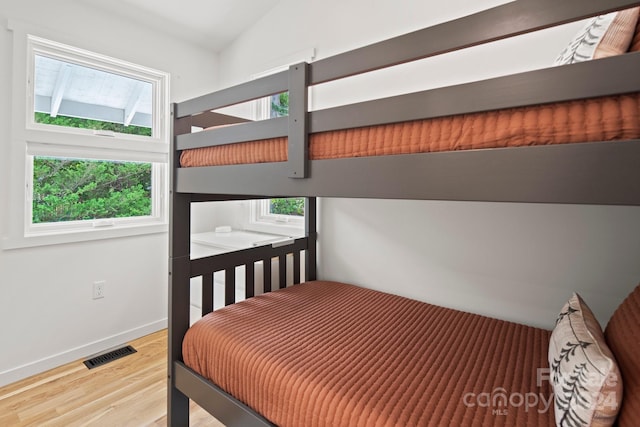 bedroom featuring hardwood / wood-style flooring and vaulted ceiling