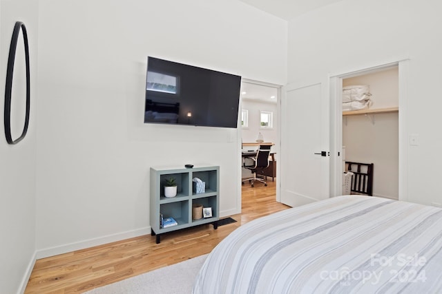 bedroom featuring hardwood / wood-style flooring, a spacious closet, and a closet