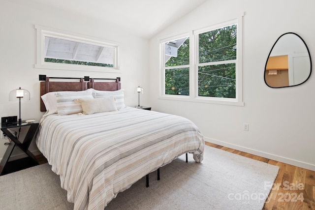 bedroom featuring lofted ceiling and wood-type flooring