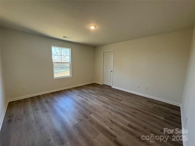 empty room with dark hardwood / wood-style flooring