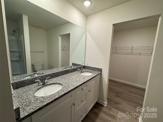 bathroom featuring wood-type flooring, vanity, and toilet