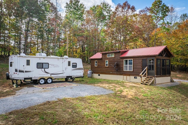 view of front of house with a sunroom and a front yard