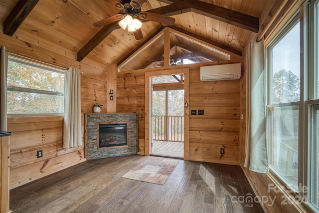 unfurnished living room featuring dark hardwood / wood-style floors, an AC wall unit, and a healthy amount of sunlight