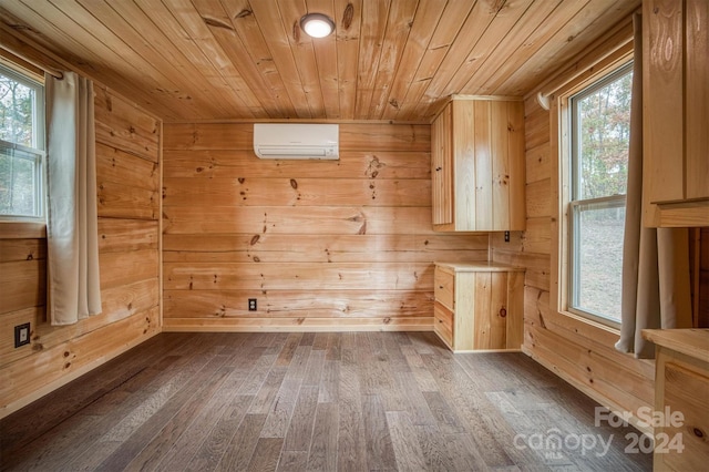 interior space with an AC wall unit, wood walls, hardwood / wood-style floors, and wooden ceiling