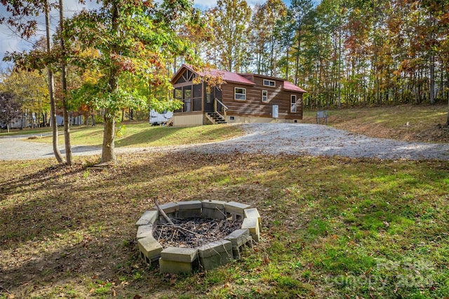 view of yard with a sunroom and a fire pit