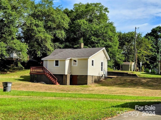 exterior space with a shed, a wooden deck, and a lawn