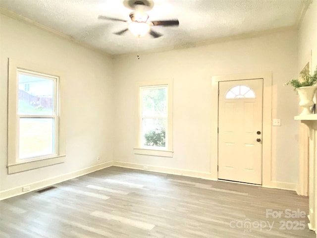 entrance foyer featuring baseboards, visible vents, ceiling fan, wood finished floors, and a textured ceiling