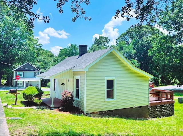 rear view of property with a shingled roof, a lawn, a chimney, crawl space, and a wooden deck