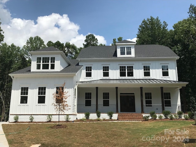 modern farmhouse style home featuring a porch and a front yard