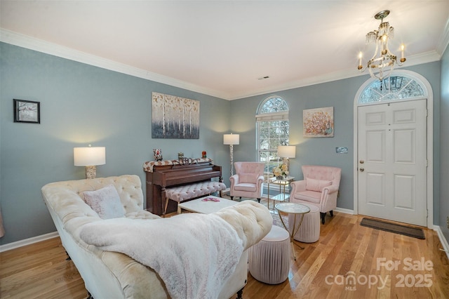 living room featuring ornamental molding, light hardwood / wood-style flooring, a wealth of natural light, and a notable chandelier