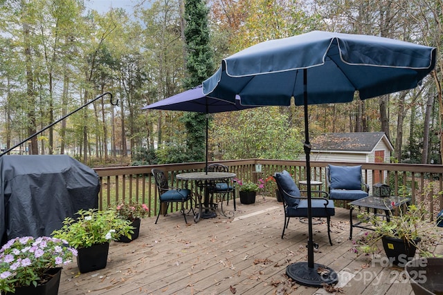 wooden deck featuring area for grilling and an outdoor structure