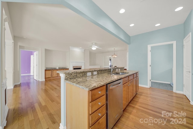 kitchen with stainless steel dishwasher, sink, a kitchen island with sink, and light hardwood / wood-style flooring