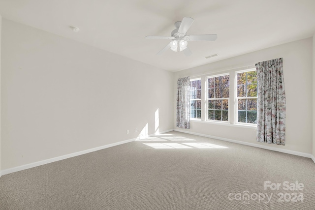 spare room with ceiling fan and carpet